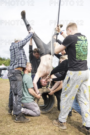 Festival visitors drinking from a funnel on a campsite at the Rock am Ring Festival on Saturday, Nürburgring race track race track, 07.06.2025