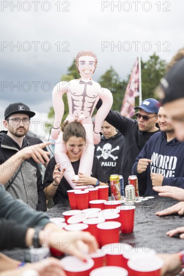 Festival visitors play a drinking game on a campsite at the Rock am Ring Festival on Saturday, Nürburgring race track race track, 07.06.2025