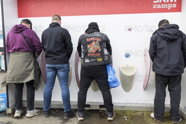 Four gentlemen at Pissiors at the Rock am Ring Festival on Friday, Nürburgring race track race track, 07.06.2025