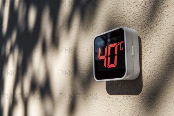 Digital termometer showing 40 degrees fahrenheit temperature on wall in hot summer. Generative ai, AI generated
