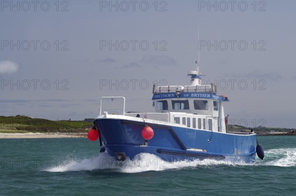 Large blue boat in motion on wavy sea with red buoy, passenger ferry, Isles of Scilly, Cornwall, England, Great Britain
