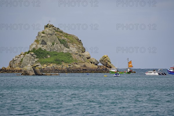 Boats in the sea near a small rocky island under a blue sky, Tresco, Isles of Scilly, Cornwall, England, United Kingdom
