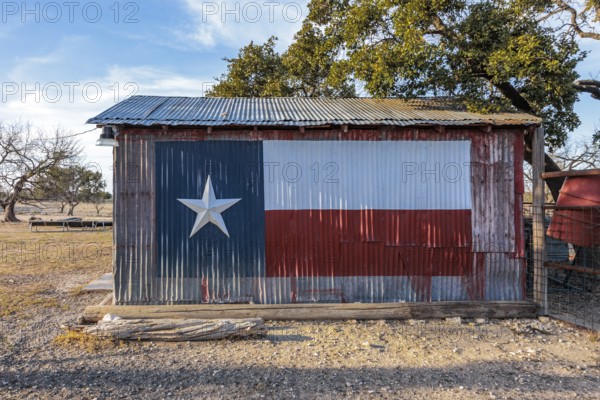 Texas state flag painted on a storage shed building on a private ranch in Sonora, Texas, USA