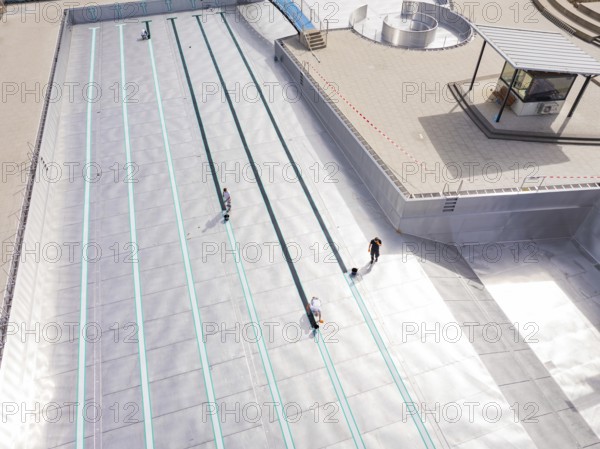 High-angle shot of a swimming pool under construction with workers, renovation of the swimming lines, Calw Stammheim outdoor pool, Calw, Black Forest, Germany