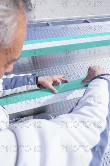 Worker adjusts stripes in the swimming pool with his hands, renewal of the swimming lines, Calw Stammheim outdoor pool, Calw, Black Forest, Germany