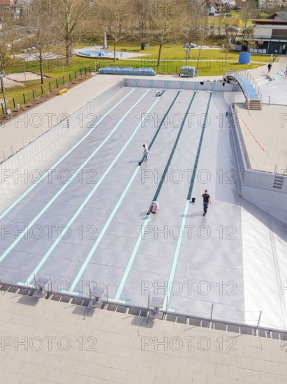 People working at an empty swimming pool in a green environment, renewal of the swimming lines, Calw Stammheim outdoor pool, Calw, Black Forest, Germany