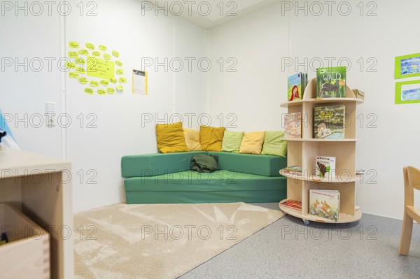 Cosy reading corner in a kindergarten with colourful cushions and books, transitional daycare centre in container construction, Gechingen daycare centre, Calw district, Germany