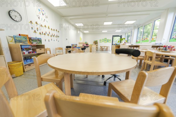 Kindergarten room with round table, wooden furniture and toys, bright atmosphere, transitional daycare centre in container construction, Gechingen daycare centre, Calw district, Germany