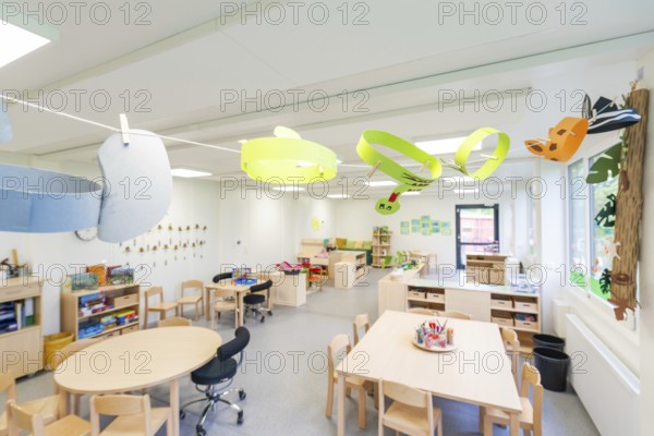 Creatively designed learning space with colourful paper decorations and wooden furniture, transitional daycare centre in container construction, Gechingen daycare centre, Calw district, Germany