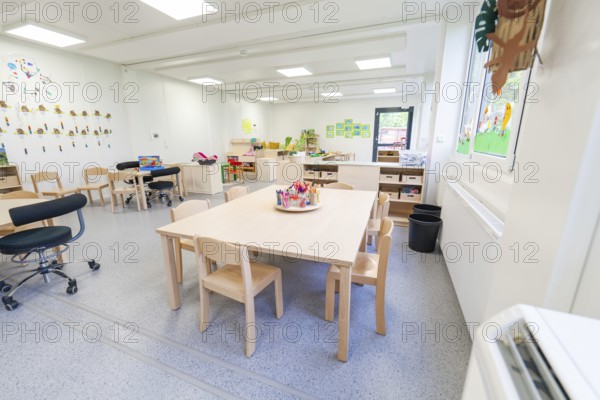 Learning room with tables and chairs, surrounded by bright windows and decorations, transitional containerised daycare centre, Gechingen daycare centre, Calw district, Germany