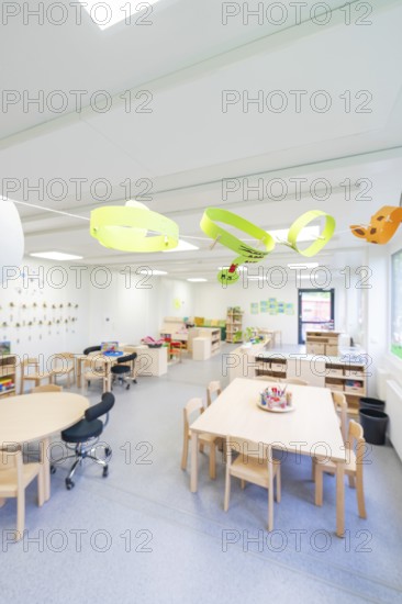 Open school classroom with paper artwork and wooden furniture, transitional containerised daycare centre, Gechingen daycare centre, Calw district, Germany