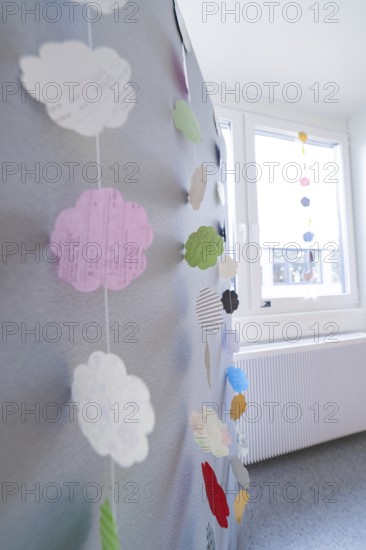 Colourful paper cloud decoration hangs near a window, transitional daycare centre in container construction, Gechingen daycare centre, Calw district, Germany