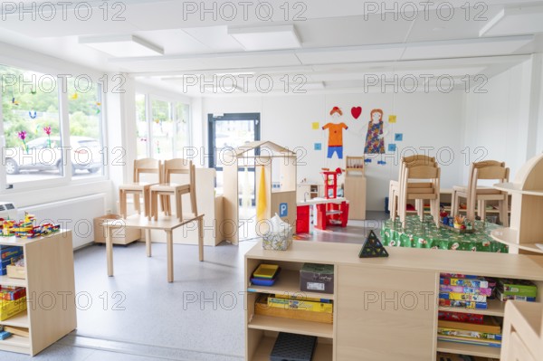 Bright room with toys, set-up chairs and shelves in the foreground, transitional daycare centre in container construction, Gechingen daycare centre, Calw district, Germany