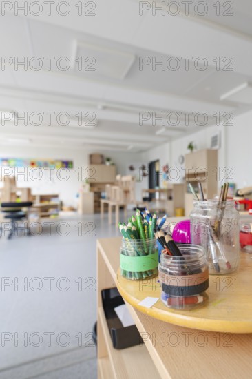 Close-up of art tools and pencils on a table in a sunny room, transitional daycare centre in container construction, Gechingen daycare centre, Calw district, Germany