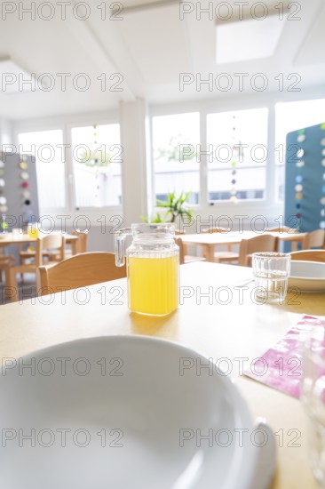 Close-up of a laid table with juice jug and bright window light, transitional daycare centre in container construction, Gechingen daycare centre, Calw district, Germany