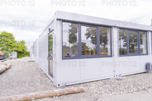 Exterior view of a modern modular building with decorated windows, transitional daycare centre in container construction, Gechingen daycare centre, Calw district, Germany