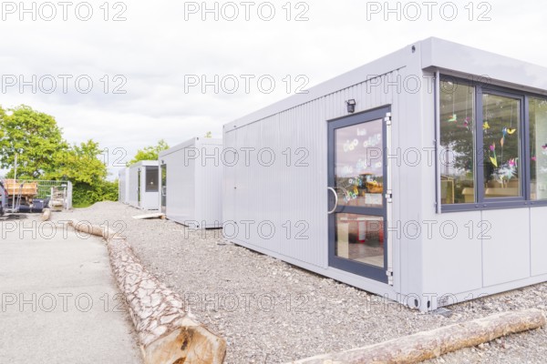 Plain grey containers in an area surrounded by trees, transitional daycare centre in container construction, Gechingen daycare centre, Calw district, Germany