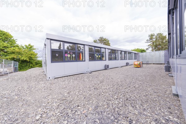 Elongated modern building with large windows and gravel floor, transitional daycare centre in container construction, Gechingen daycare centre, Calw district, Germany