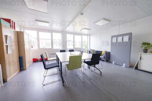 Modern meeting room with chairs around a table, large windows create light, transitional daycare centre in container design, Gechingen daycare centre, Calw district, Germany