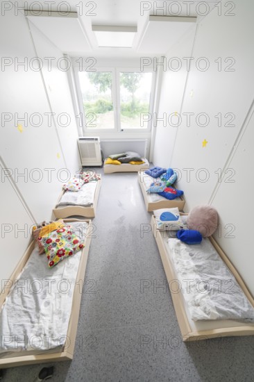 Overview of a dormitory for children with beds, lit by windows, transitional containerised daycare centre, Gechingen daycare centre, Calw district, Germany