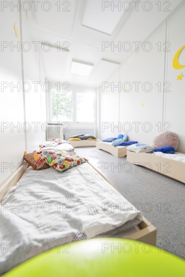 Sleeping room for children with beds and colourful cushions, flooded with light and quiet, transitional daycare centre in container construction, Gechingen daycare centre, Calw district, Germany