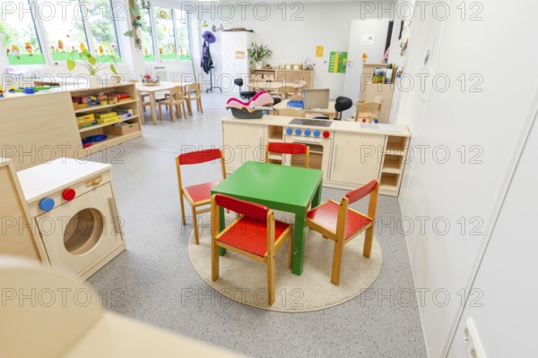 Children's room with colourful chairs and a small play kitchen on carpet, transitional daycare centre in container construction, Gechingen daycare centre, Calw district, Germany