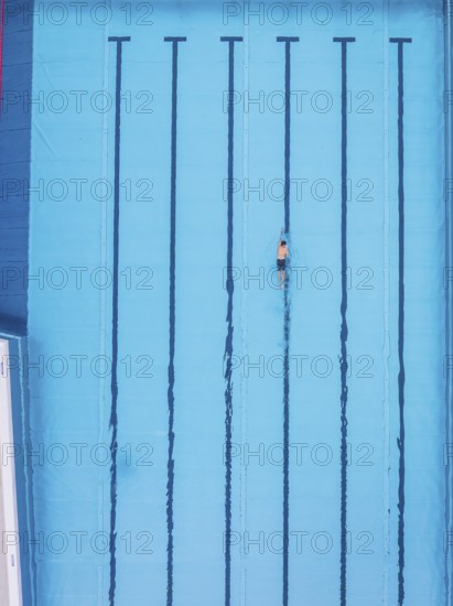 A single swimmer in an empty pool, the water is calm and clear, Calw outdoor pool, Black Forest, Germany