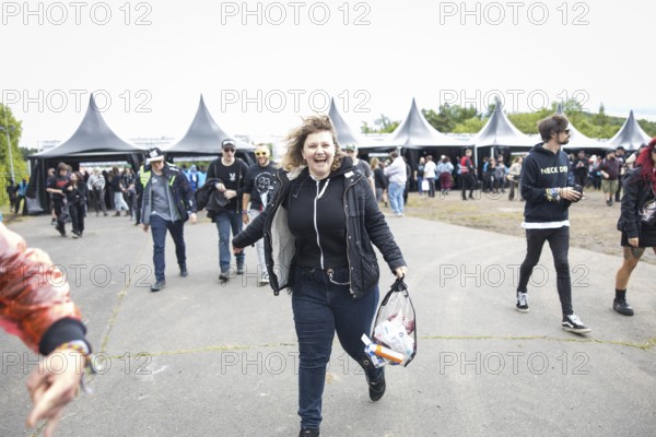 A festival visitor runs after passing the main entrance at the Rock am Ring Festival on Friday, Nürburgring race track race track, 06/06/2025