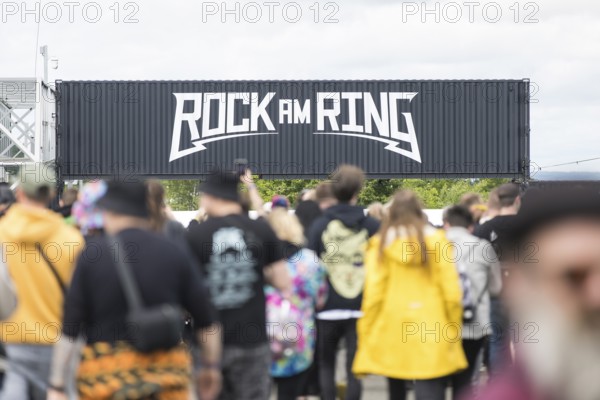 Festival visitors in front of a container with Rock am Ring logo at the Rock am Ring Festival on Friday, Nürburgring race track race track, 06.06.2025