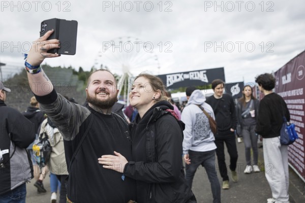 Festival visitors Kevin and Jenny take a photo in front of a container with the Rock am Ring logo at the Rock am Ring Festival on Friday, Nürburgring race track race track, 06.06.2025