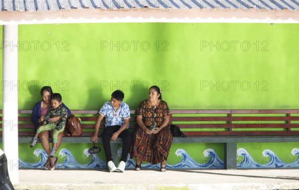 Guatemalans wait at the boat dock in Livingston on the Rio Dulce River, Izabal Department, Guatemala