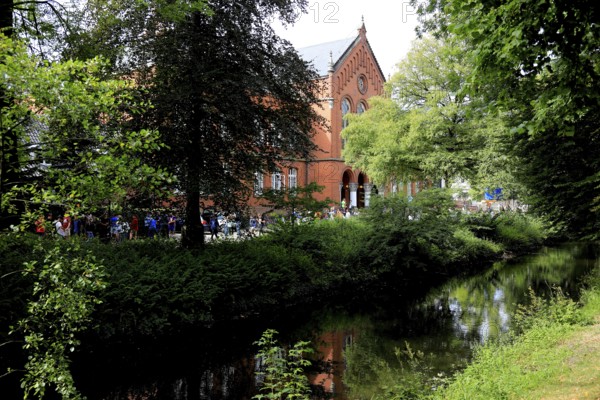 The Old Gymnasium Oldenburg was built in the style of round arch historicism based on designs by architect Heinrich Strack the Elder. The hair flows in the foreground of the photo, Lower Saxony, Germany