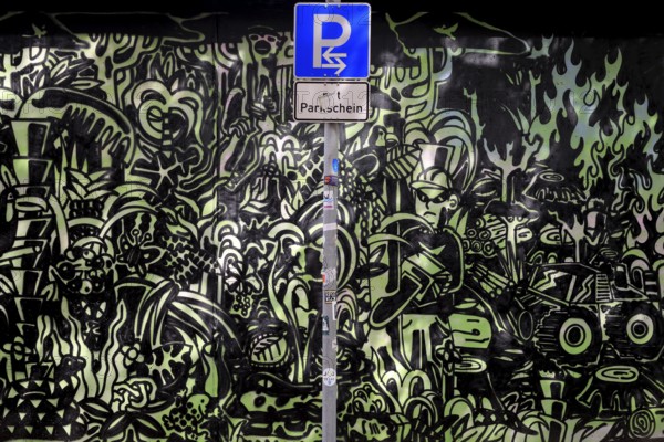 Parking sign in front of a graphite wall