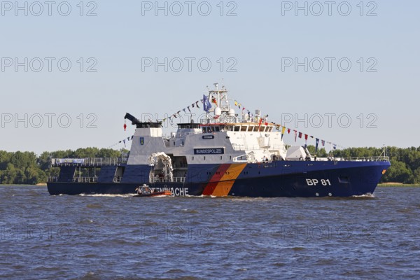 Decorated ship of the German Coast Guard and Federal Police BP 81 Potsdam leaves the Port of Hamburg on the Elbe after Hamburg's port birthday, Wedel, Schleswig-Holstein, Germany