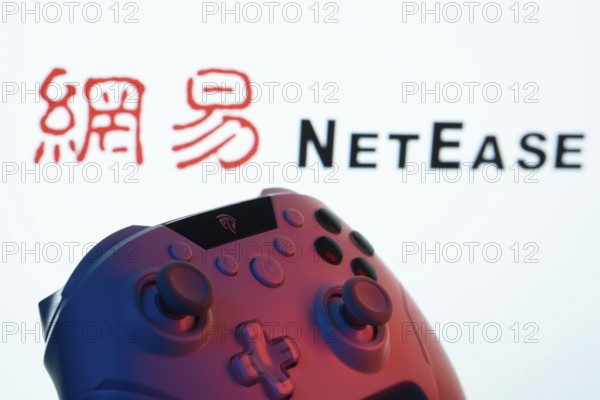 Dhaka, Bangladesh- 20 Mar 2025: A close-up of a gamepad with the NetEase seen on screen in the background
