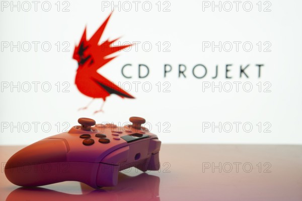 Dhaka, Bangladesh- 20 Mar 2025: A close-up of a white gamepad with the CD Projekt seen on screen in the background