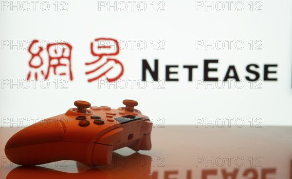 Dhaka, Bangladesh- 20 Mar 2025: A close-up of a gamepad with the NetEase seen on screen in the background