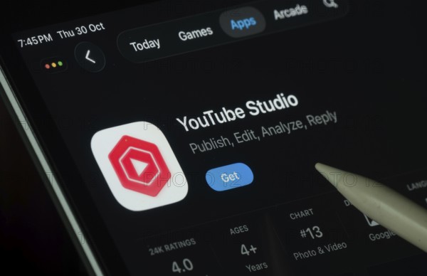 Dhaka, Bangladesh- 30 Oct 2025: Youtube Studio app displayed on a iPad screen in dark mode with a digital pen pointing at it