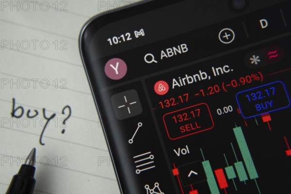 Dhaka, Bangladesh- 20 June 2025: Airbnb stock trading details displayed on smartphone with handwritten note