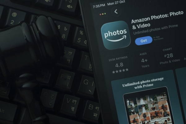 Dhaka, Bangladesh- 28 Oct 2025: An iPad displaying the Amazon photos app against a judge's gavel and dark keyboard background