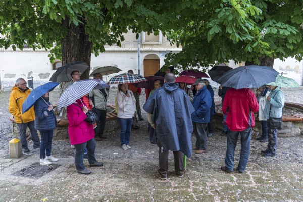 Travel group in case of rain in the courtyard of St. Margaret's Church, Medias, Romania