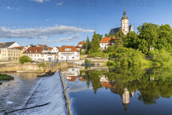 City view with church of Our Lady on the mountains and reflection in Zwickauer Mulde, Staustufe, Penig, Saxony, Germany