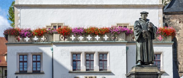 The monument to Martin Luther on the market square in Eisleben, Luther monument, bronze sculpture from 1883 by Rudolf Siemering, behind it the façade of the historic town hall, Luther city Eisleben, Saxony-Anhalt, Germany