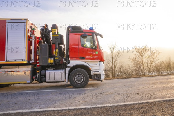 Fire engine on the road towards sunrise, landscape in the background, fire department exercise on the Hermann Hesse railway, Ostelsheim, Calw district, Germany