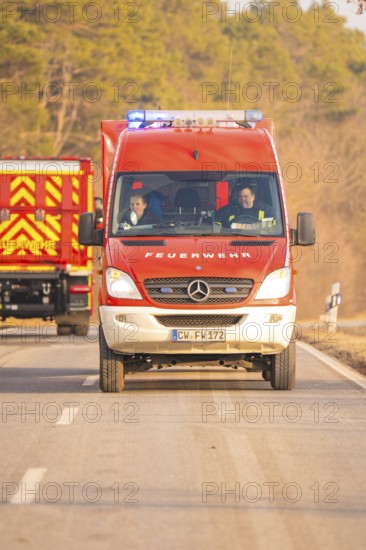 Red fire truck moving on a rural road, fire brigade exercise on the Hermann Hesse Railway, Ostelsheim, Calw district, Germany