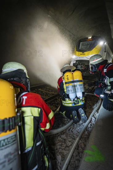 Firefighters with respirators extinguish a fire in a tunnel using water hoses, fire brigade exercise on the Hermann Hesse Railway, Ostelsheim, Germany