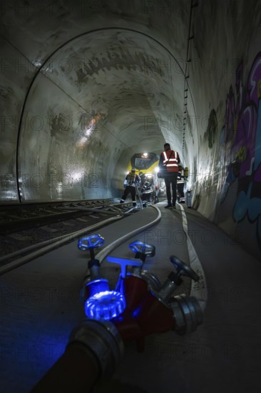 Workers in the dark railroad tunnel. Lighting and technical equipment are visible, fire department exercise on the Hermann Hesse Railway, Ostelsheim, Germany