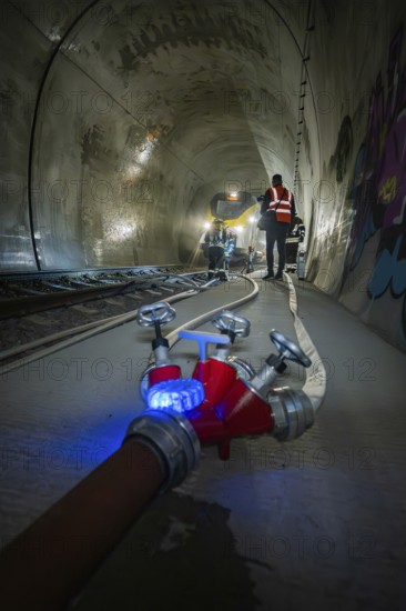A water tap and fire hose in the foreground of a tunnel, fire brigade exercise on the Hermann Hesse Railway, Ostelsheim, Germany