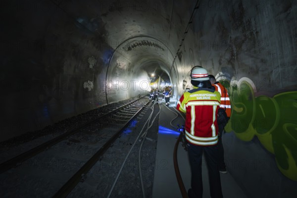 Firefighters work with hoses in a tunnel with graffiti, fire department exercise on the Hermann Hesse railway, Ostelsheim, Germany