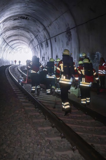 Firefighters in a tunnel focusing on darkness and equipment, fire department exercise on the Hermann Hesse railway, Ostelsheim, Germany